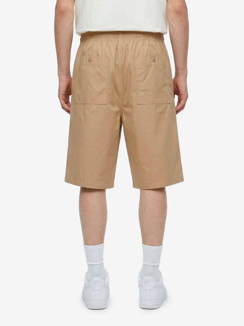 Shorts oversize beige pleated con Swoosh