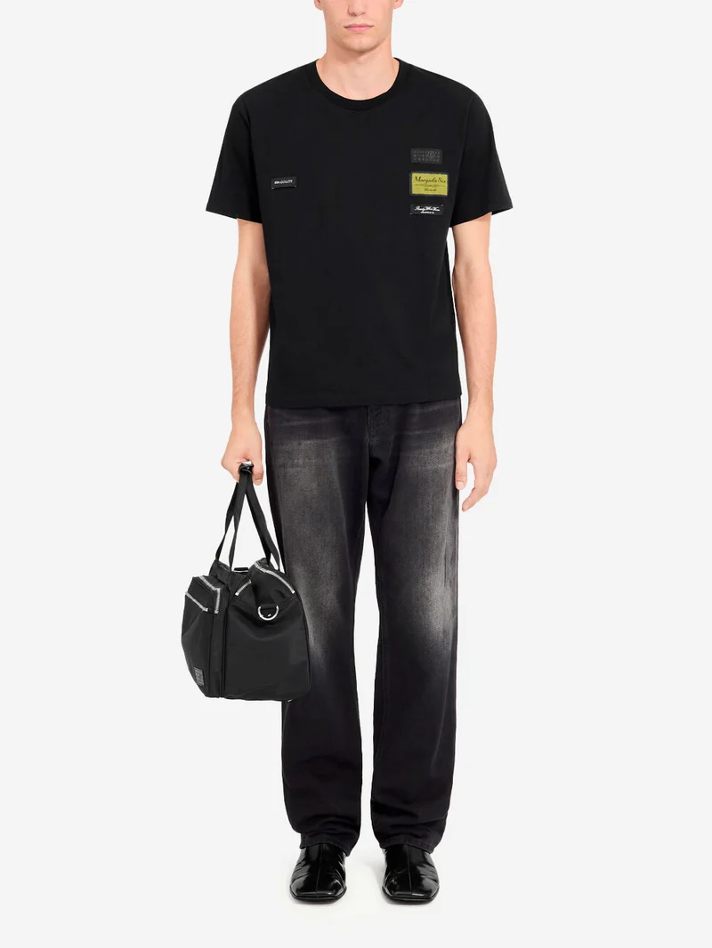 T-shirt nera con etichette esterne